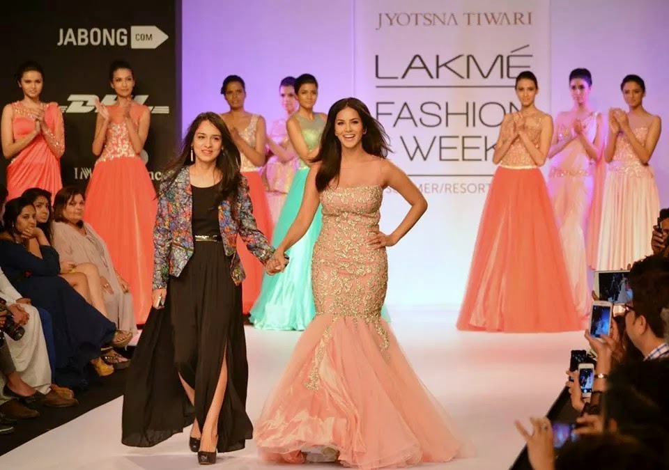 Designer and showstopper in a blush gown taking the finale bow at a fashion week event