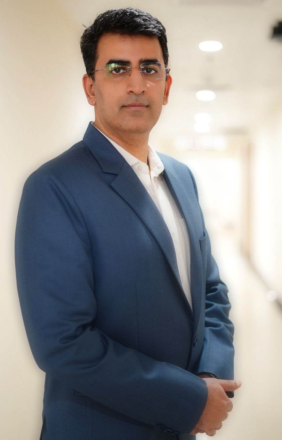 Corporate portrait of a business leader in a navy blazer photographed in an office corridor