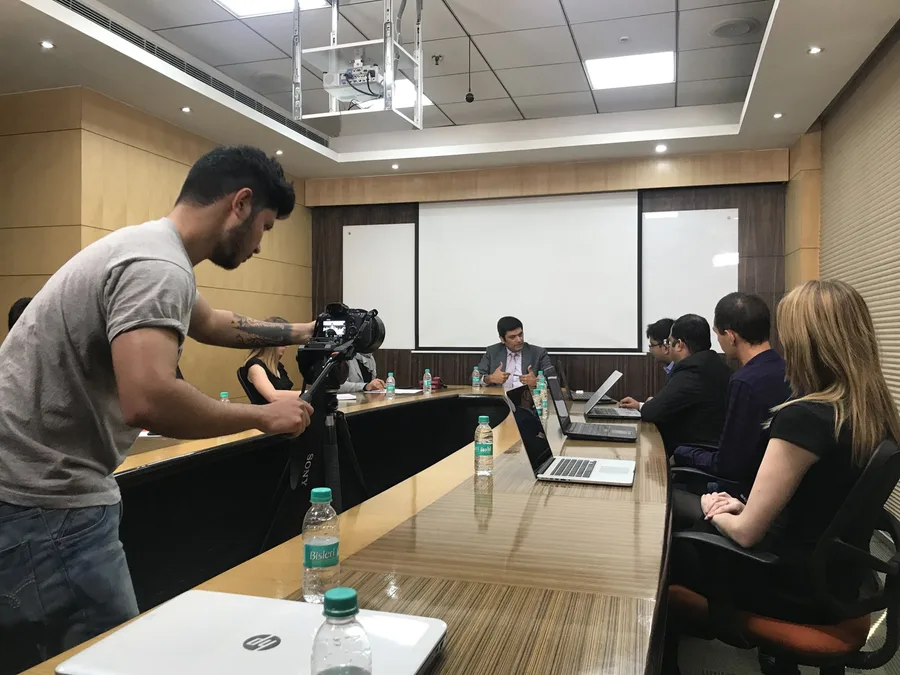 Boardroom interview being filmed with a cinema camera on tripod