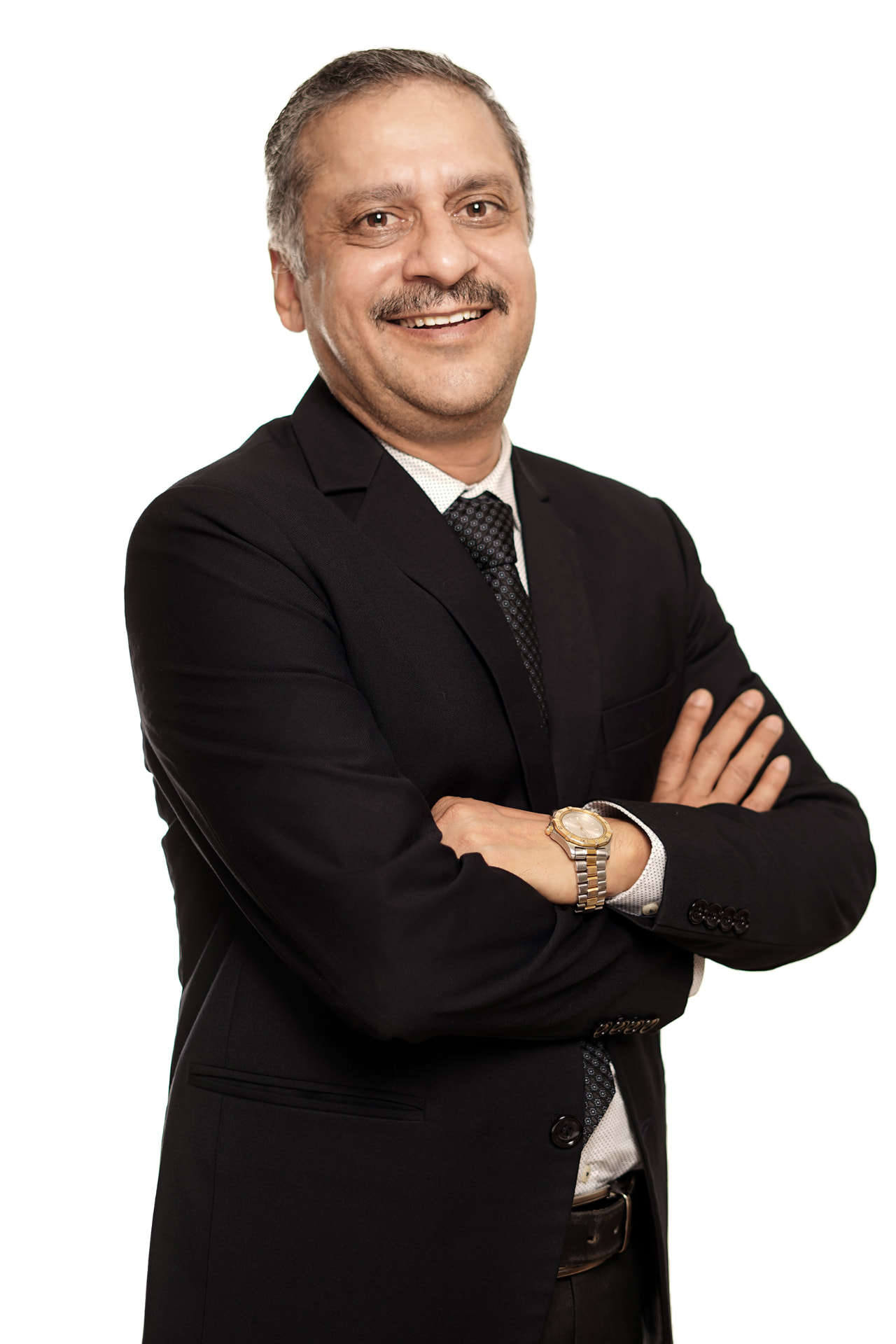 Studio corporate headshot of an executive in a black suit with arms folded on a white background